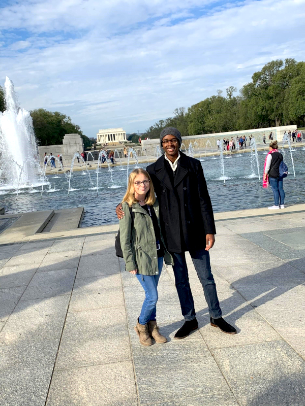 Two students in Washington DC in front of water fountain.